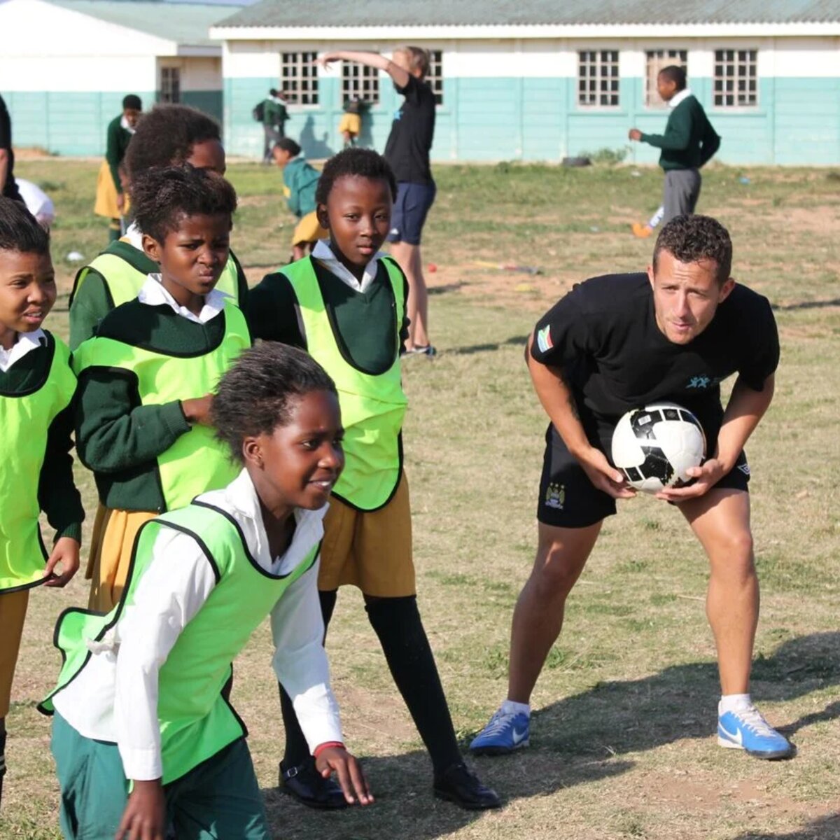 Traveller coaching children in South Africa playing football