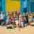 Group of people in bikinis in front of colourful beach huts in Melbourne