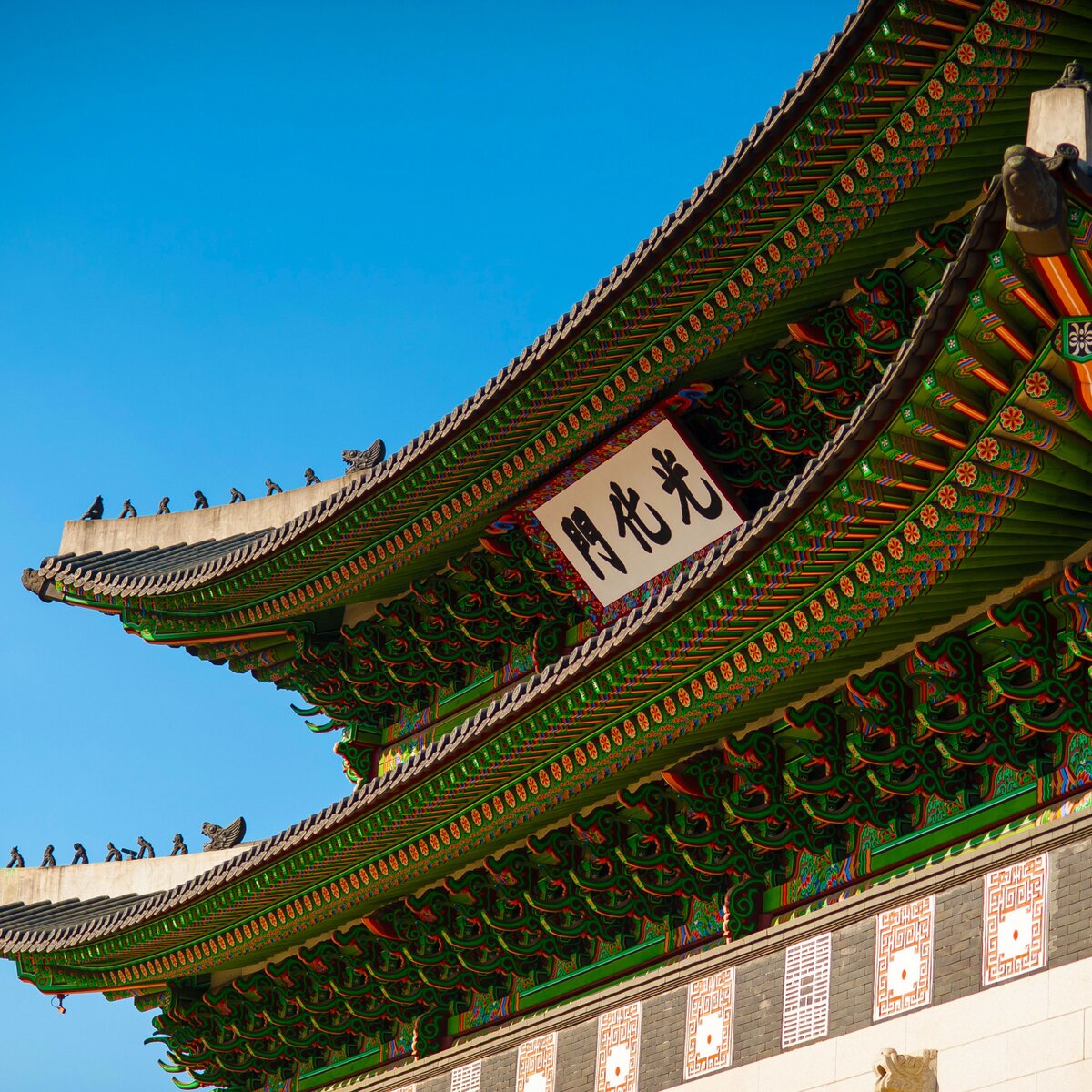 Green temple with Korean writing on a backdrop of blue sky